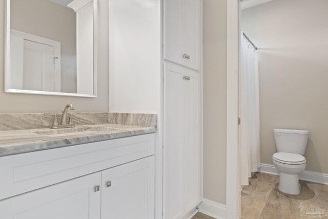 bathroom featuring vanity, tile patterned flooring, and toilet