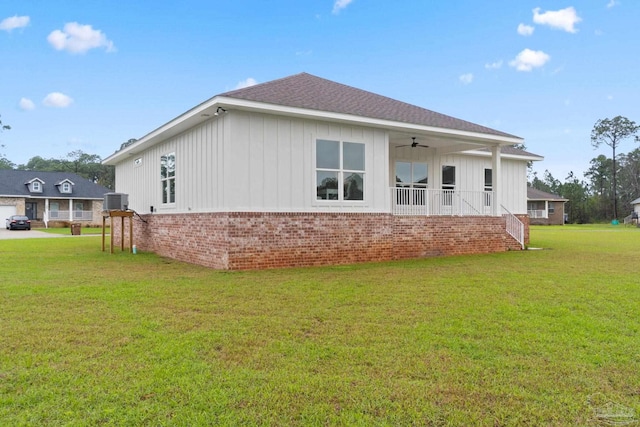 rear view of property with ceiling fan and a lawn