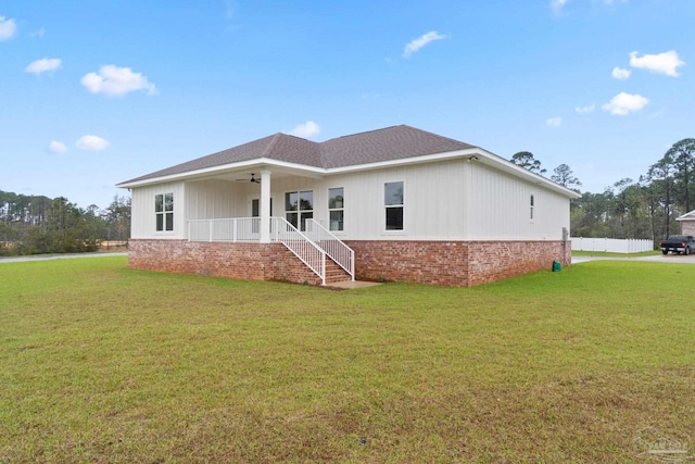 view of front facade featuring ceiling fan, covered porch, and a front lawn