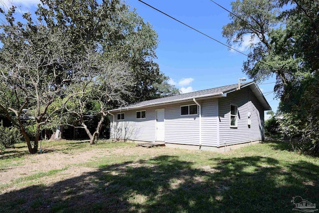 rear view of property featuring a lawn