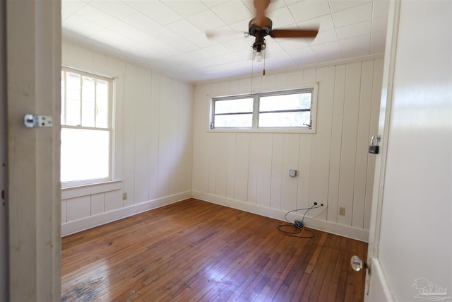 unfurnished room featuring hardwood / wood-style floors, ceiling fan, and a healthy amount of sunlight