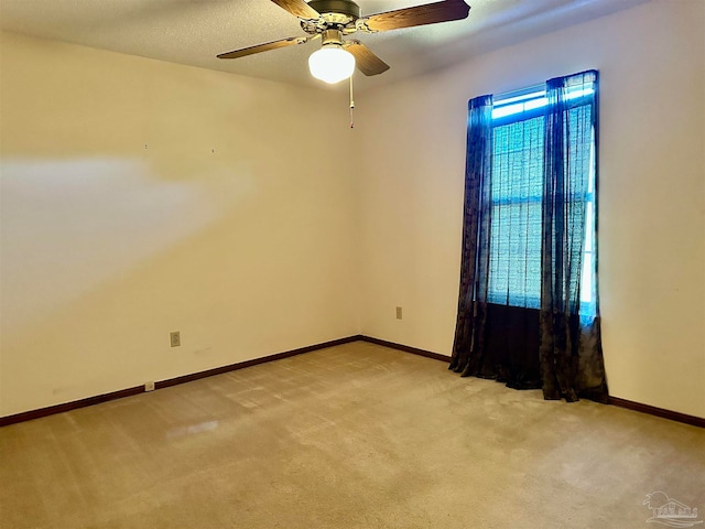 spare room with light colored carpet and ceiling fan