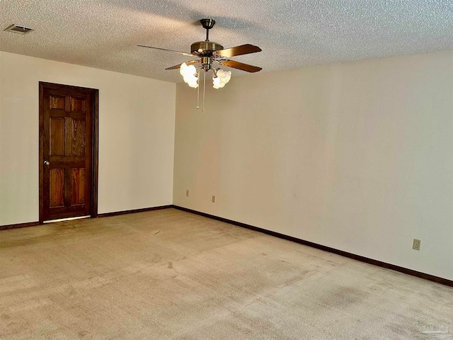 unfurnished room featuring ceiling fan, light carpet, and a textured ceiling