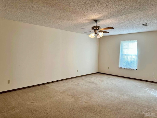 carpeted spare room with ceiling fan and a textured ceiling