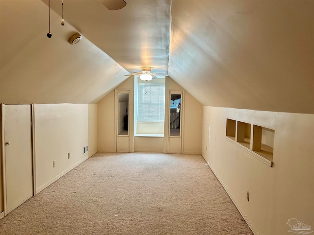 bonus room with lofted ceiling and light colored carpet