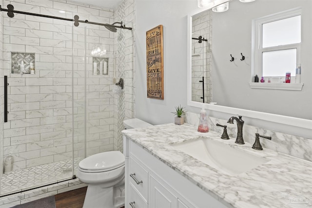 bathroom with hardwood / wood-style floors, vanity, toilet, and a shower with door