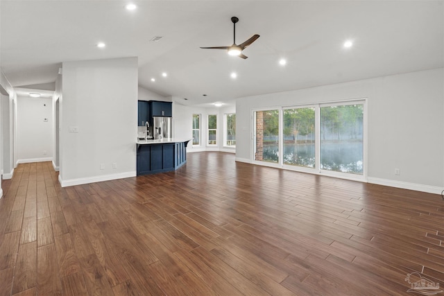 unfurnished living room with dark hardwood / wood-style flooring, ceiling fan, and lofted ceiling