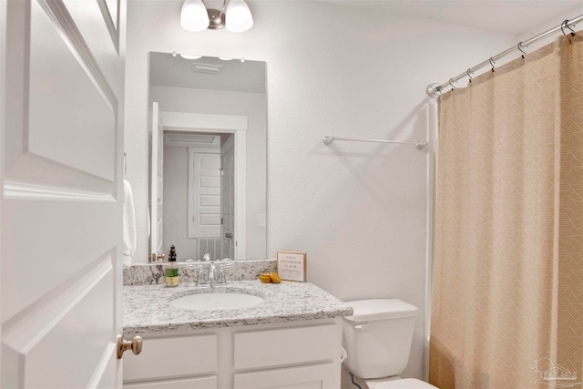 bathroom with vanity, toilet, and curtained shower