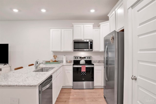 kitchen featuring sink, white cabinets, light wood-type flooring, appliances with stainless steel finishes, and light stone counters