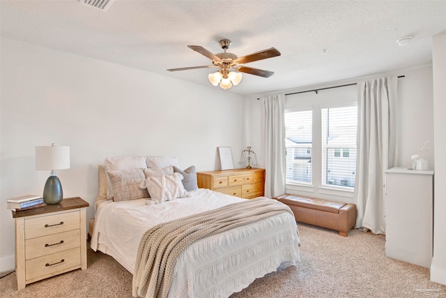 carpeted bedroom featuring a textured ceiling and ceiling fan