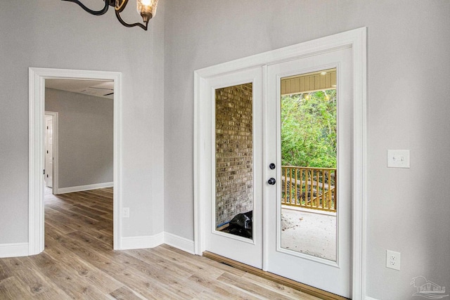 doorway with a chandelier, french doors, and hardwood / wood-style flooring