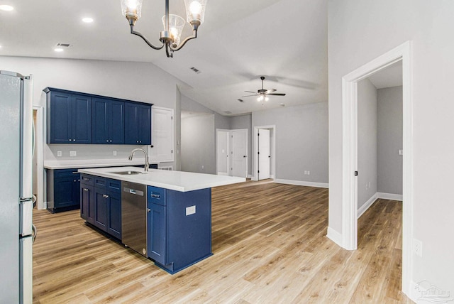 kitchen featuring ceiling fan with notable chandelier, stainless steel appliances, light hardwood / wood-style floors, blue cabinetry, and vaulted ceiling