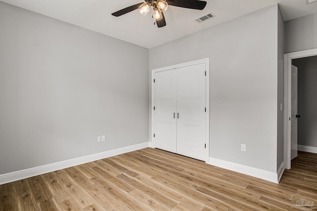 unfurnished bedroom featuring light wood-type flooring, ceiling fan, and a closet