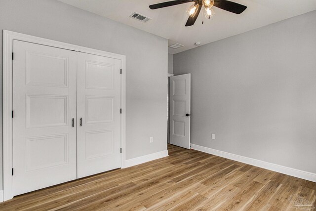 unfurnished bedroom with light hardwood / wood-style flooring, a closet, and ceiling fan