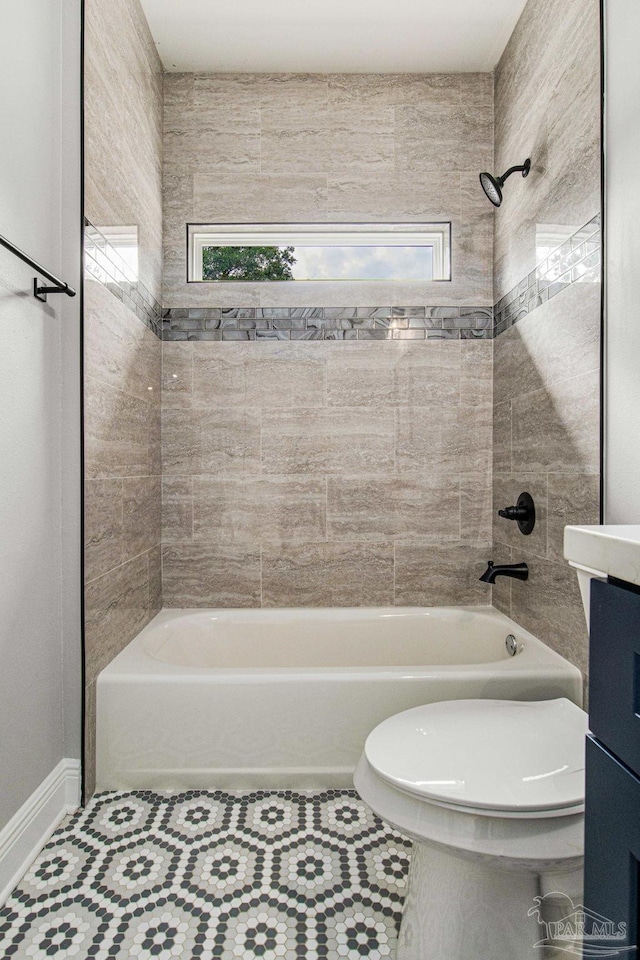 full bathroom with a wealth of natural light, toilet, vanity, and tiled shower / bath