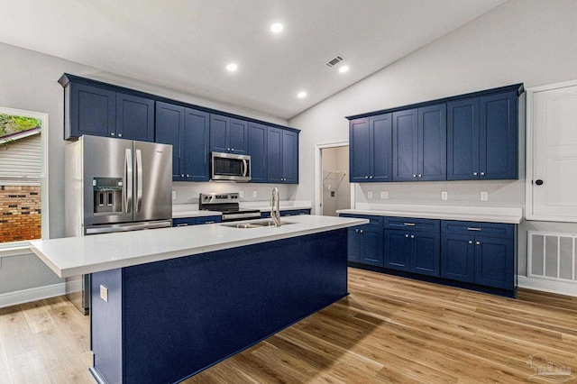 kitchen featuring light hardwood / wood-style floors, appliances with stainless steel finishes, blue cabinetry, vaulted ceiling, and sink