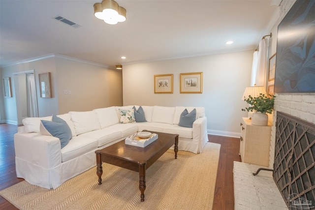 living room with a fireplace, hardwood / wood-style flooring, and crown molding