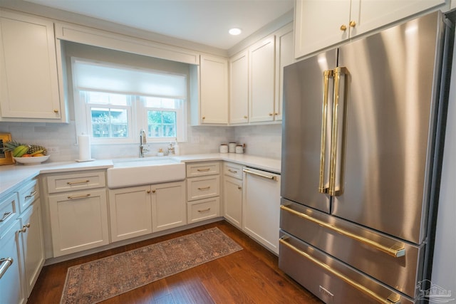 kitchen with white cabinets, sink, high quality fridge, tasteful backsplash, and dark hardwood / wood-style flooring