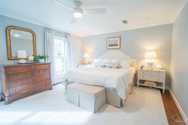 bedroom with light hardwood / wood-style flooring, ceiling fan, and crown molding