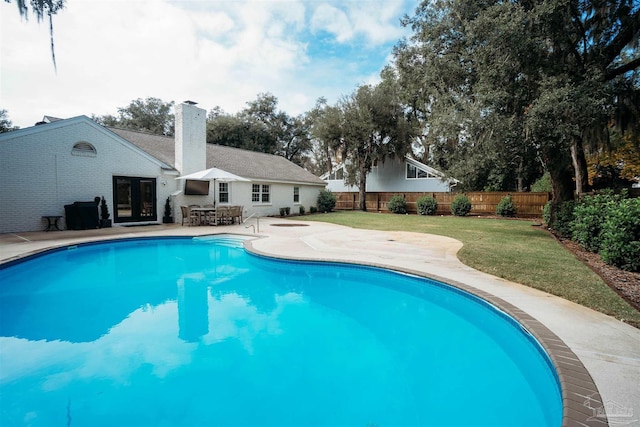 view of swimming pool with a lawn, a patio area, and french doors