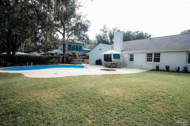 view of swimming pool with a jacuzzi, cooling unit, a patio area, and a lawn