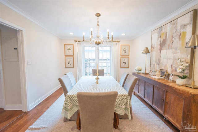 dining space with crown molding, a chandelier, and hardwood / wood-style flooring