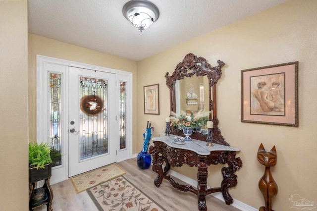 foyer featuring a textured ceiling and light hardwood / wood-style flooring