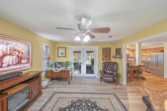 sitting room featuring french doors, light hardwood / wood-style flooring, and ceiling fan