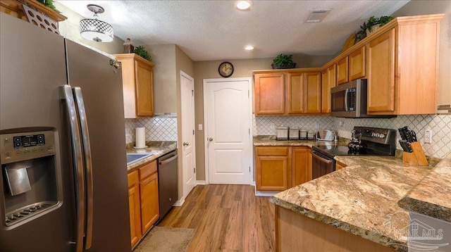 1462 Camrose Pl, Pensacola, FL 32534 - kitchen with appliances with stainless steel finishes, light wood-style floors, decorative backsplash, light countertops, and recessed lighting