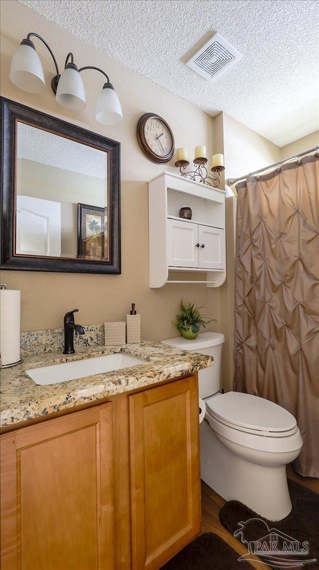 1462 Camrose Pl, Pensacola, FL 32534 - full bathroom featuring a textured ceiling, vanity, toilet, wood finished floors, and curtained shower