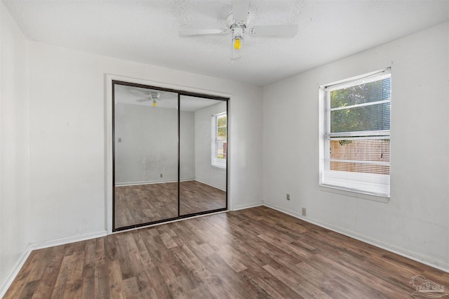 unfurnished bedroom featuring ceiling fan, a closet, and multiple windows