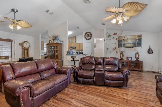 living room featuring lofted ceiling, light wood-type flooring, and ceiling fan