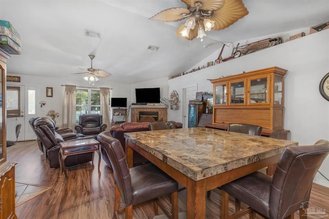 dining space with lofted ceiling, wood-type flooring, and ceiling fan