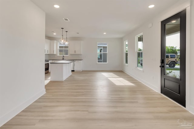 2120 W Desoto St, Pensacola, FL 32505 - unfurnished living room featuring recessed lighting, a sink, baseboards, and light wood-style floors