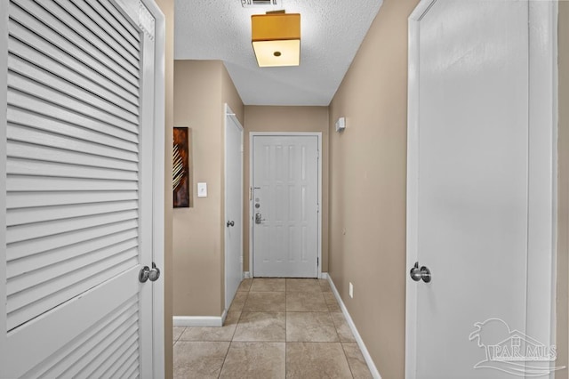 8425 Gulf Blvd Unit 206, Navarre Beach, FL 32566 - doorway featuring light tile patterned floors, visible vents, baseboards, and a textured ceiling