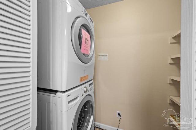 8425 Gulf Blvd Unit 206, Navarre Beach, FL 32566 - washroom featuring baseboards, laundry area, and stacked washer / dryer