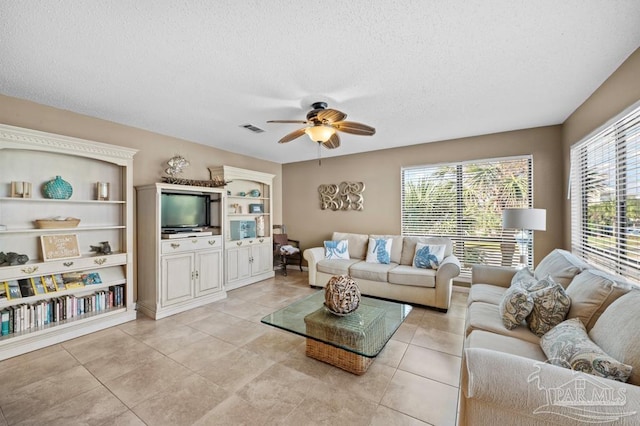 8425 Gulf Blvd Unit 206, Navarre Beach, FL 32566 - living room featuring a ceiling fan, light tile patterned floors, visible vents, and a textured ceiling