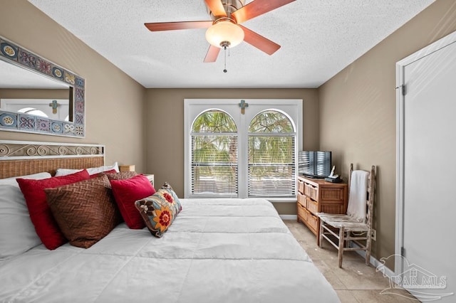 8425 Gulf Blvd Unit 206, Navarre Beach, FL 32566 - bedroom with tile patterned floors, ceiling fan, and a textured ceiling