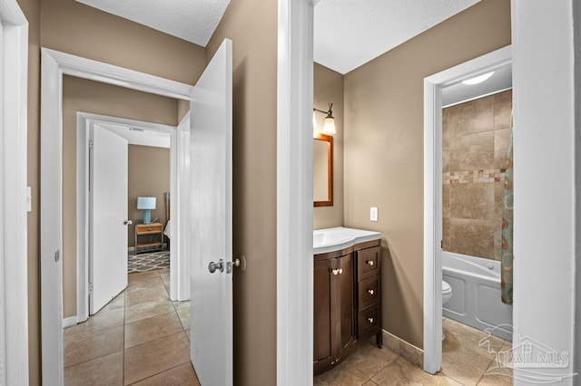 8425 Gulf Blvd Unit 206, Navarre Beach, FL 32566 - bathroom with toilet, vanity, a textured ceiling, tile patterned floors, and baseboards