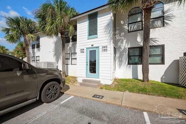 8425 Gulf Blvd Unit 206, Navarre Beach, FL 32566 - view of front of house featuring uncovered parking, stucco siding, and entry steps