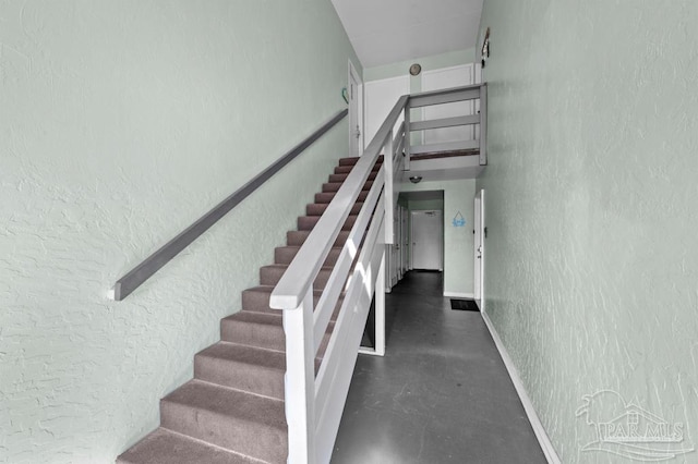 8425 Gulf Blvd Unit 206, Navarre Beach, FL 32566 - stairway with finished concrete floors, baseboards, and a textured wall