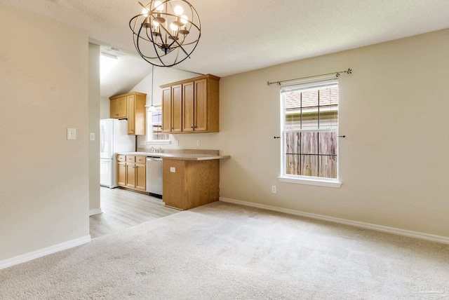6027 Dallas Ave, Pensacola, FL 32526 - kitchen featuring stainless steel dishwasher, freestanding refrigerator, a chandelier, light colored carpet, and light countertops