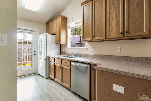 6027 Dallas Ave, Pensacola, FL 32526 - kitchen with dishwasher, light wood-style flooring, brown cabinetry, and freestanding refrigerator