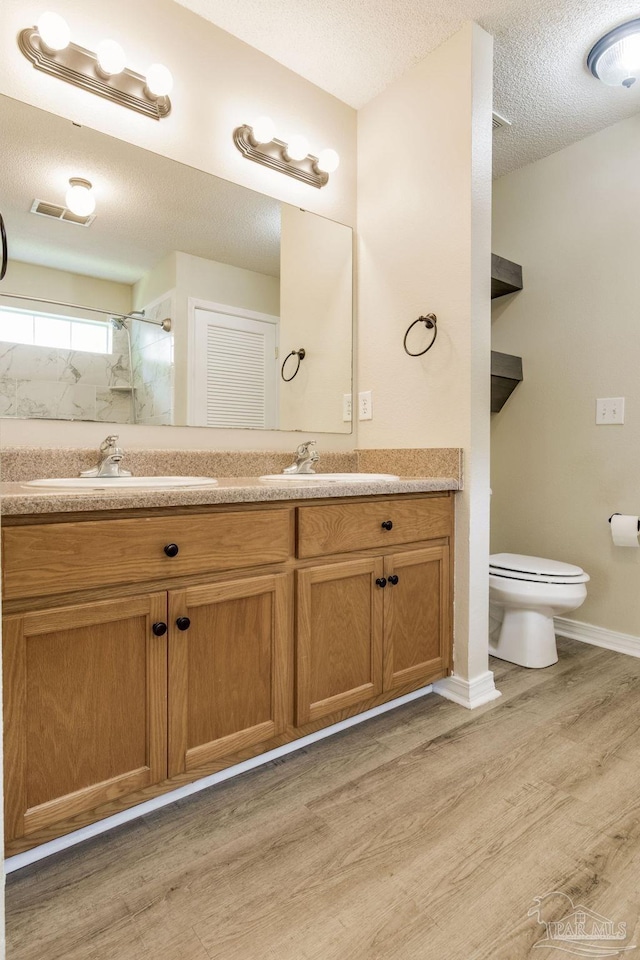 6027 Dallas Ave, Pensacola, FL 32526 - bathroom with double vanity, wood finished floors, a shower, and a textured ceiling
