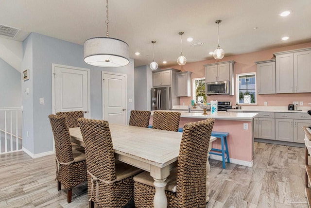 dining space featuring sink and light wood-type flooring