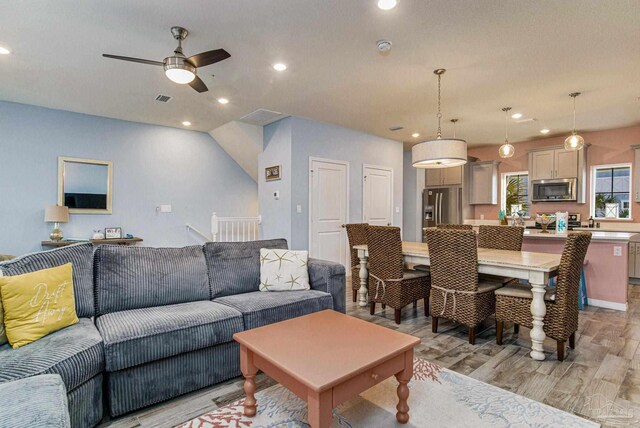 living room with ceiling fan and light hardwood / wood-style floors