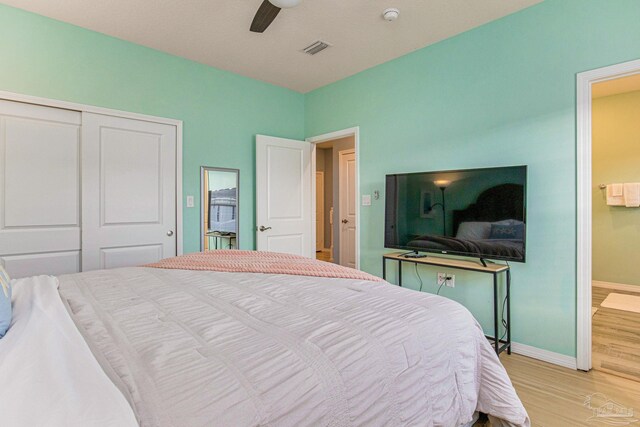 bedroom featuring ceiling fan, light hardwood / wood-style flooring, and a closet