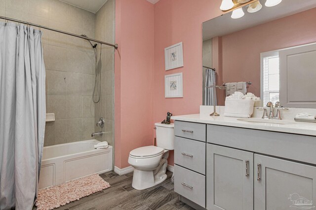 full bathroom with hardwood / wood-style flooring, vanity, shower / tub combo, and toilet