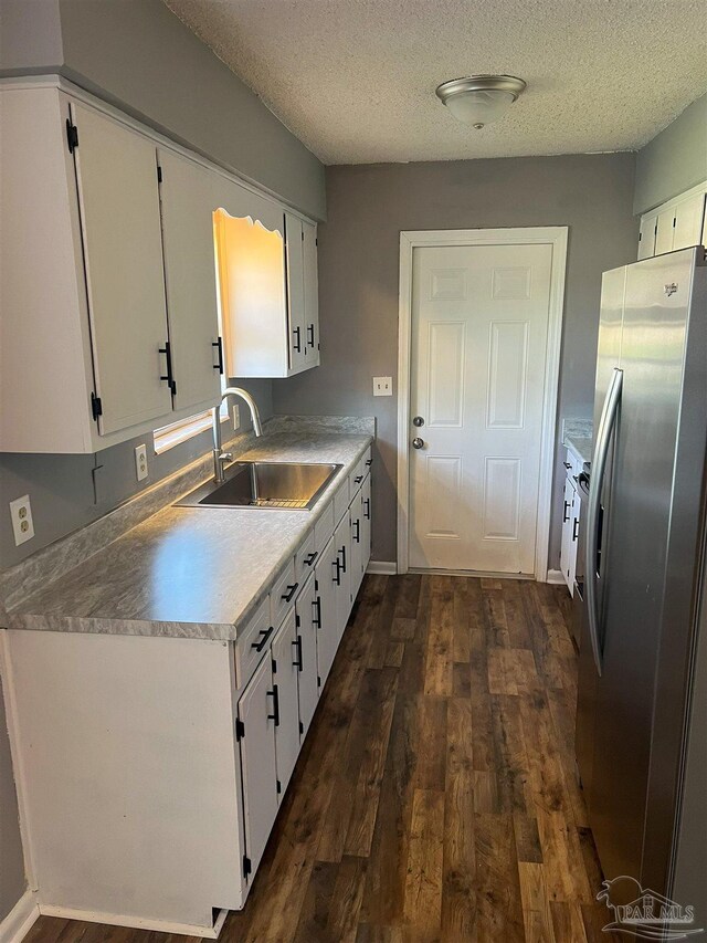 6255 Memphis Ave, Pensacola, FL 32526 - kitchen with freestanding refrigerator, a sink, dark wood finished floors, white cabinets, and a textured ceiling