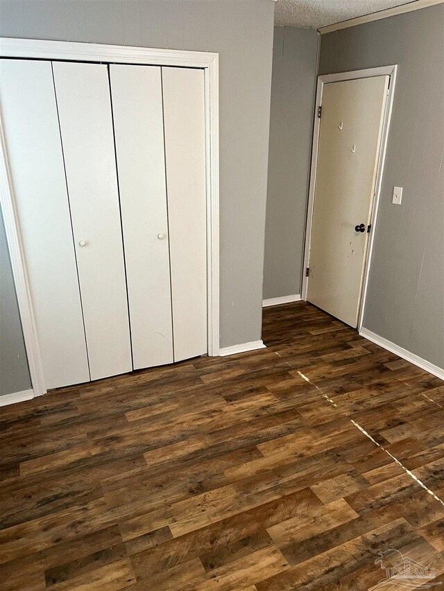 6255 Memphis Ave, Pensacola, FL 32526 - unfurnished bedroom with dark wood-style flooring, a closet, baseboards, and a textured ceiling
